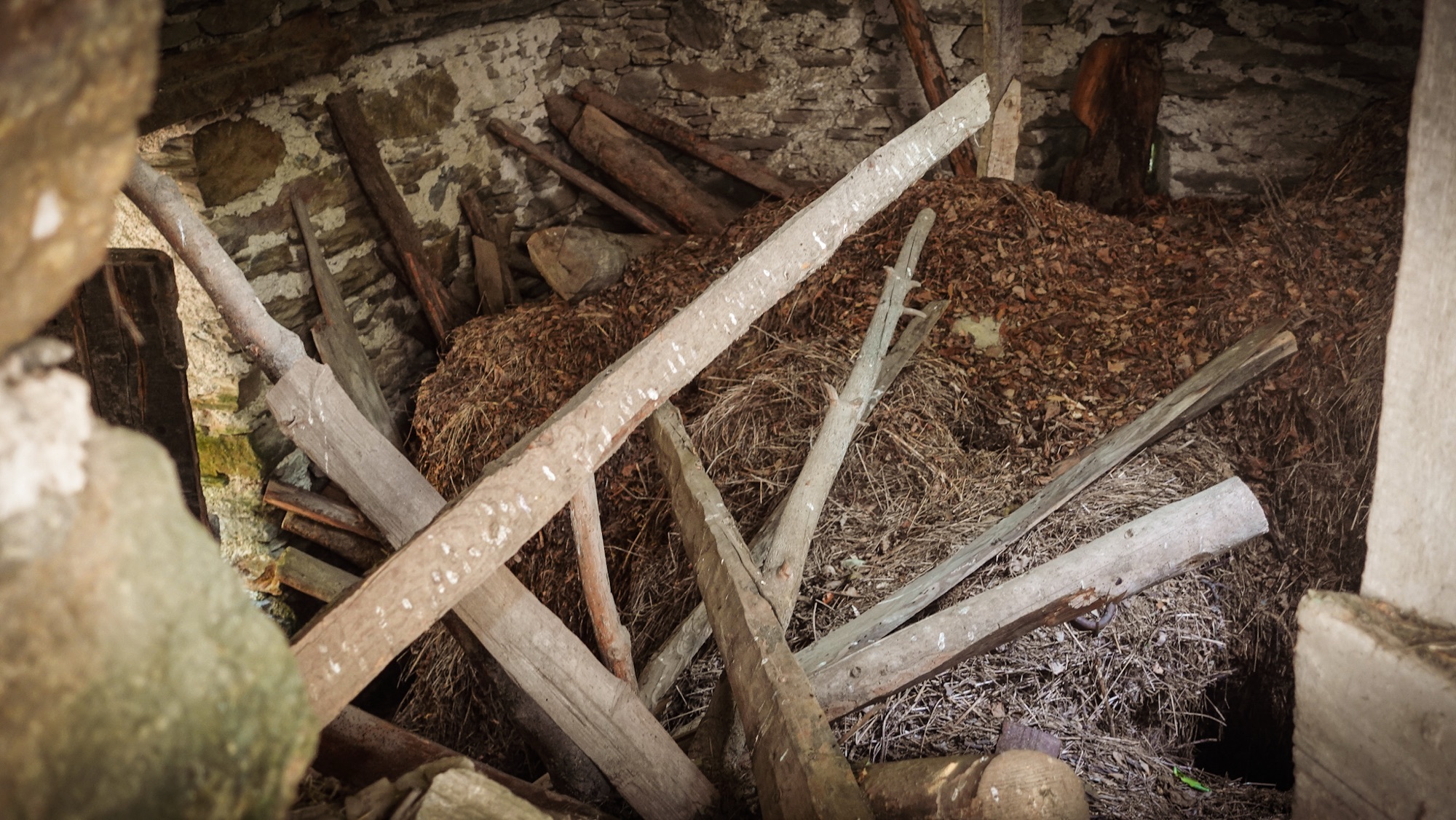 Heu und Balken in verlassenem Bergdorfhaus
