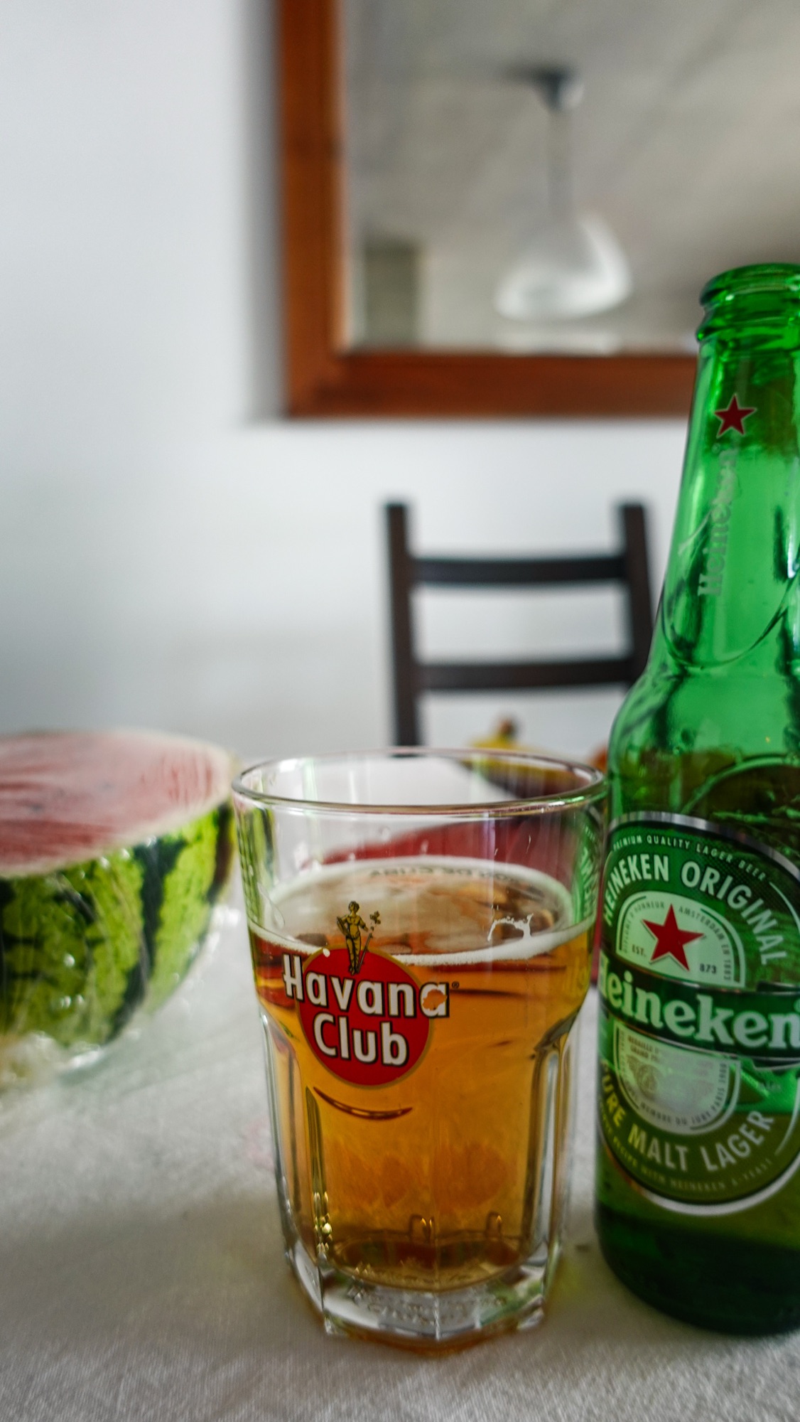 Flasche Bier Heineken und halbe Wassermelone