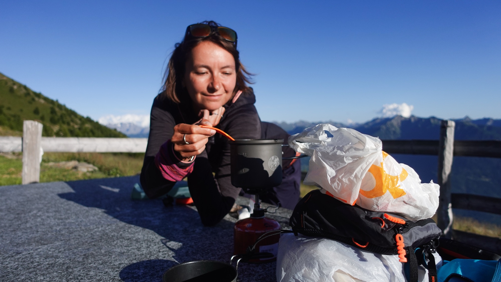 Junge Frau rührt in Camping-Topf