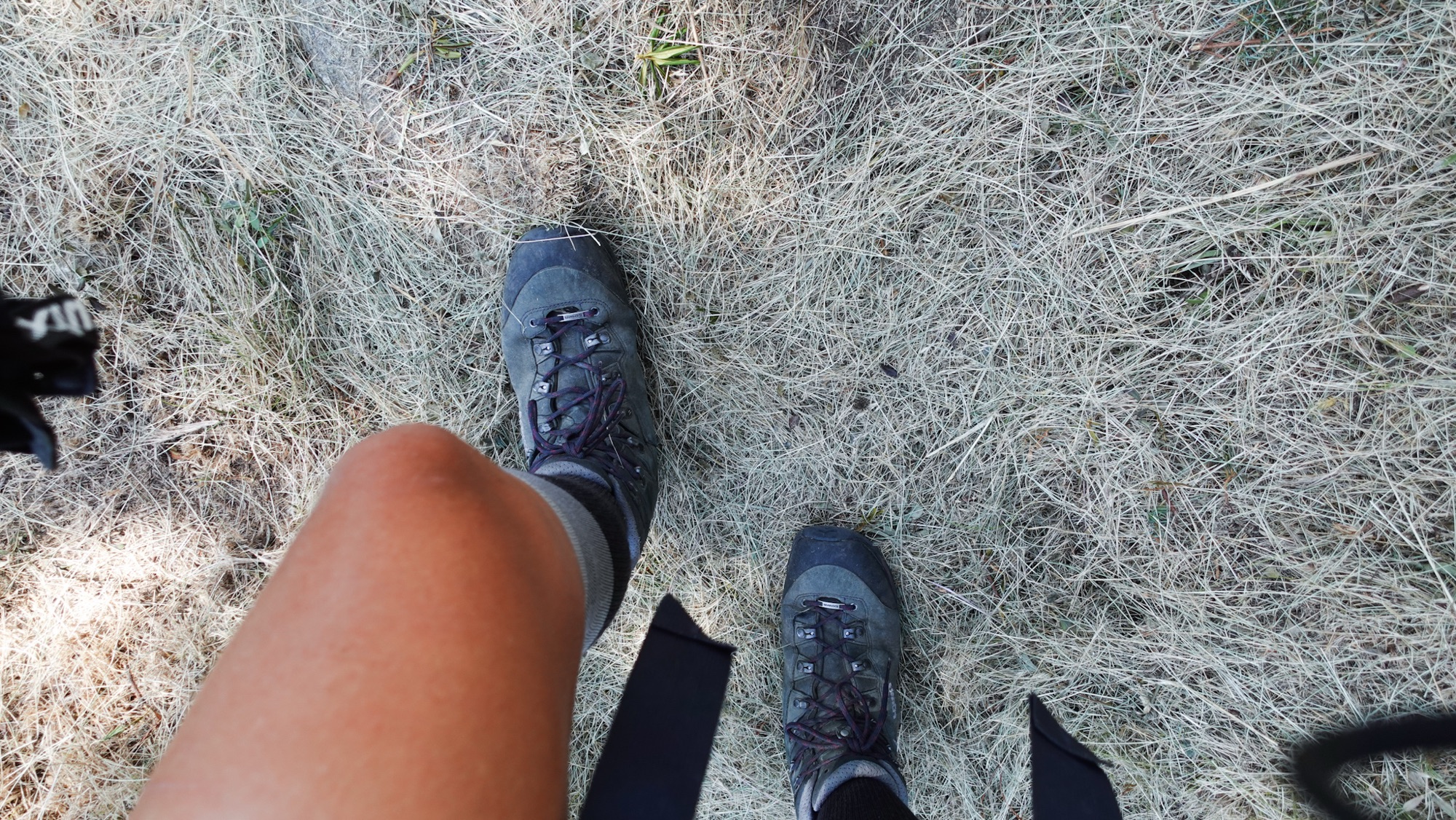 Füße wandern über trockenes Gras